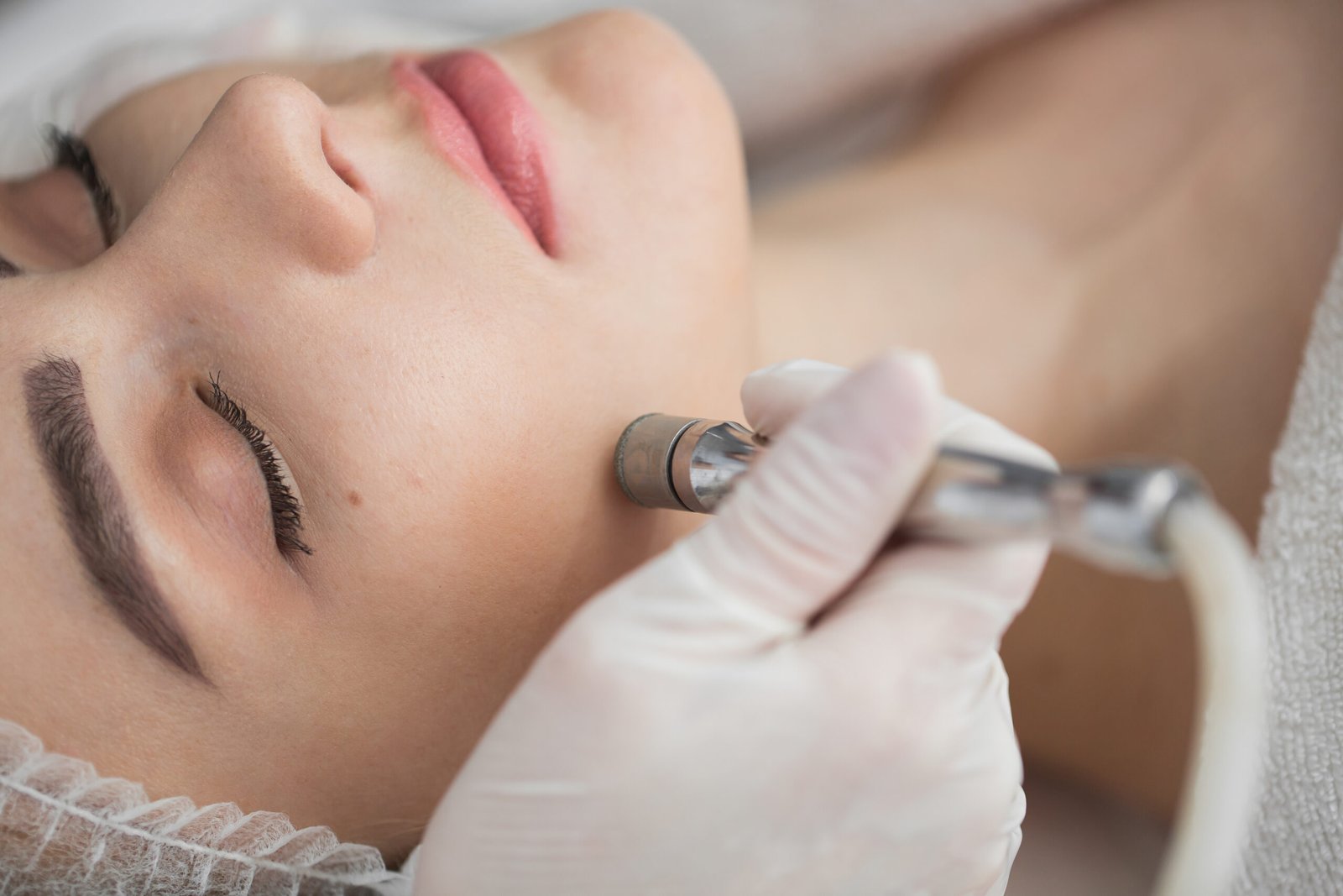 Diamond microdermabrasion, peeling cosmetic. woman during a microdermabrasion treatment in beauty salon Diamond microdermabrasion, peeling cosmetic. woman during a microdermabrasion treatment in beauty salon